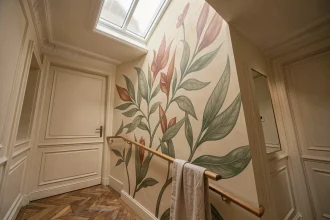 Décoration murale botanique dans une cage d'escalier de style haussmannien avec peinture végétale sage et terracotta
